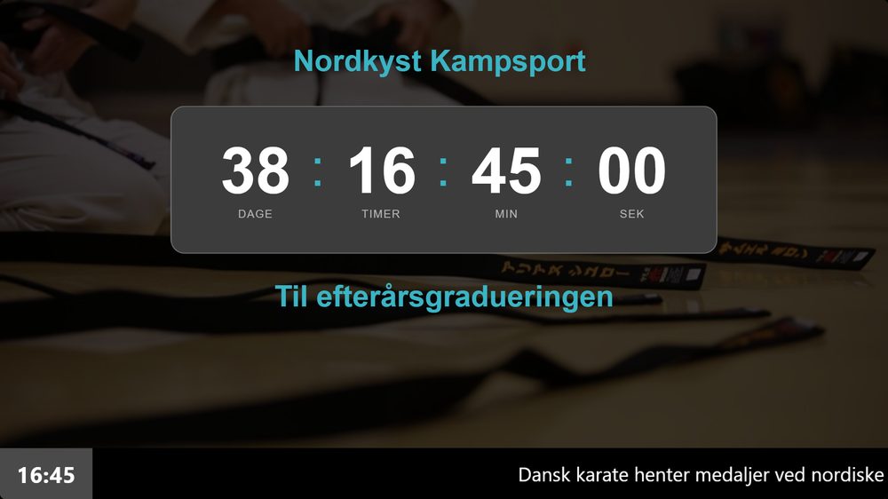 Infoskærm i en kampsportsklub der tæller ned til næste graduering i venteområdet